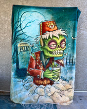 Load image into Gallery viewer, A plush blanket with a printed artwork of a zombie wearing a fez hat, with a background that includes a headstone with 'RIP' written on it.